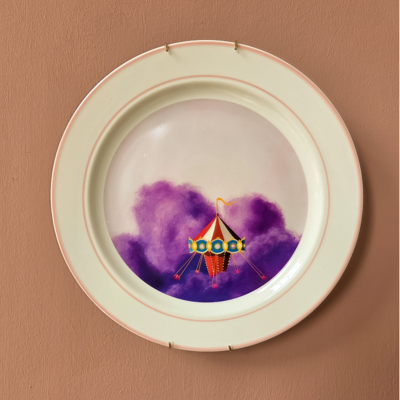 Een illustratie van een zweefmolen op een vintage wandbord met een roze rand.