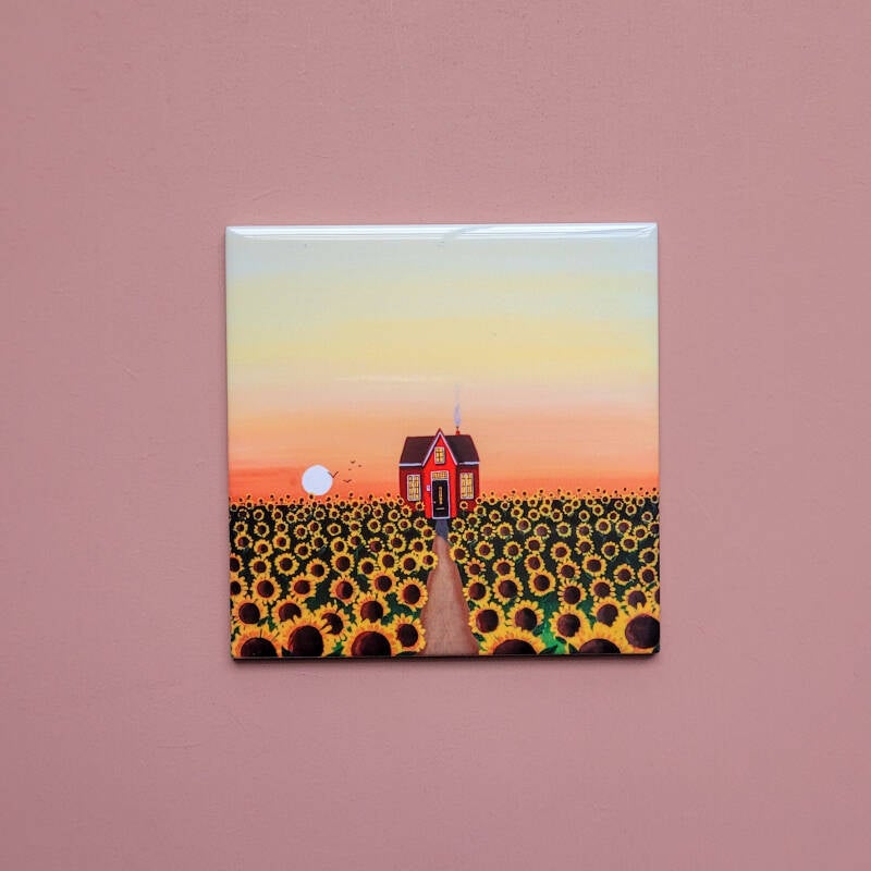 Een illustratie van zonnebloemen op een keramisch tegeltje van 10 x 10 cm.