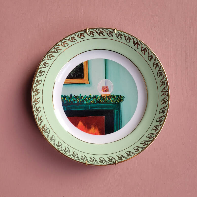 Een illustratie van een sneeuwbol op een wit vintage wandbord met een mint gouden rand.