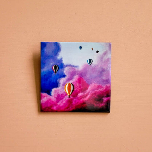 Een illustratie van kleurrijke luchtballonnen op een keramiek tegeltje.