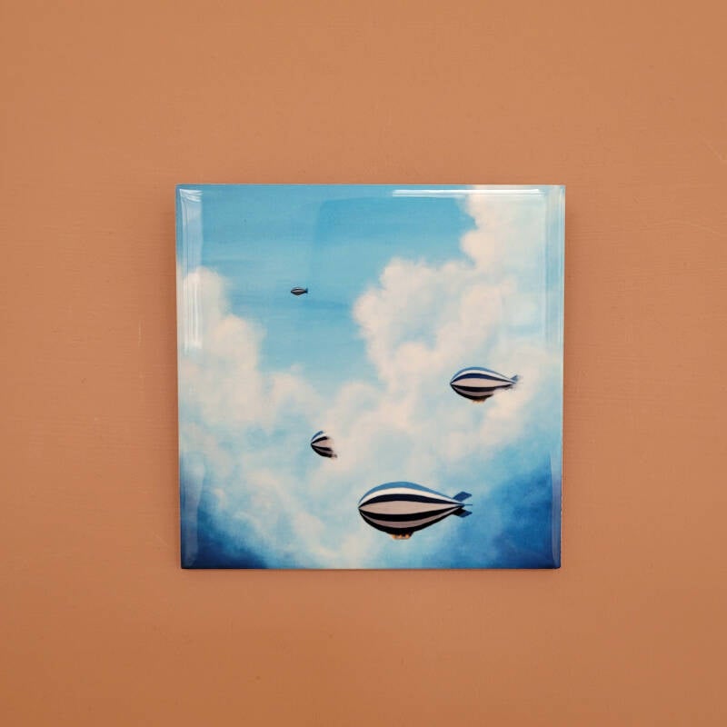Een illustratie van zeppelins op een keramisch tegeltje.