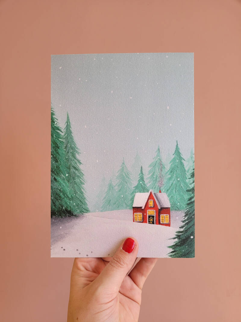 Een illustratie van een rood winterhuisje op een A5 print.