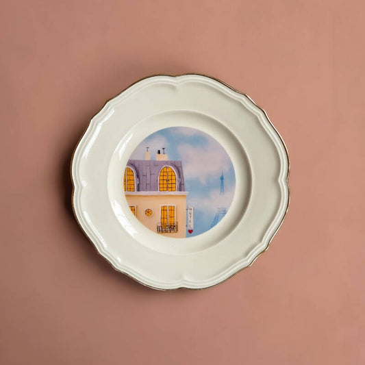 Een decoratief vintage wandbord met een illustratie van hotel Parijs op een wit bord met een gouden rand.