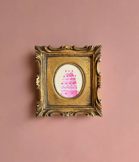 Een schilderij van een feestelijke taart in een gouden lijst.